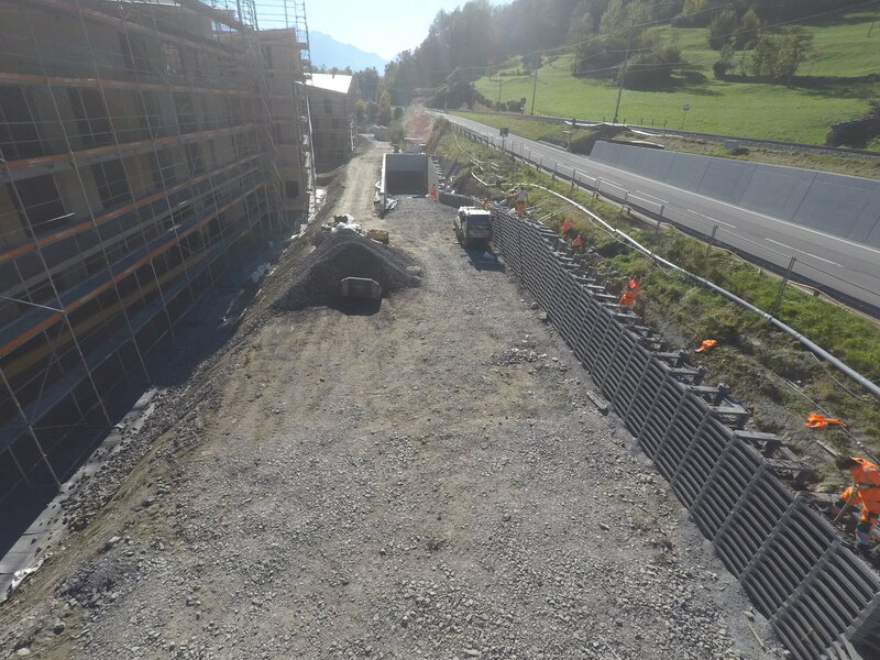 Lange Stützmauer an Strassenböschung zu abgesenkter Bauparzelle