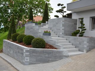 Gartentreppe aus grauem Naturstein | Lobsiger Gartenbau AG